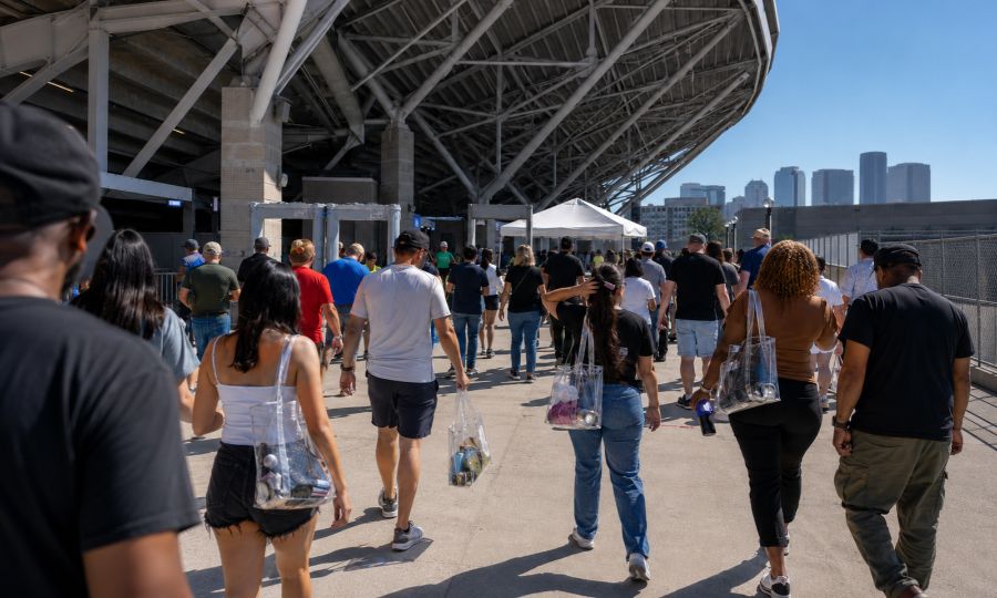 Fans lined up at a Lumen Field entrance gate holding clear bags before a Seahawks game