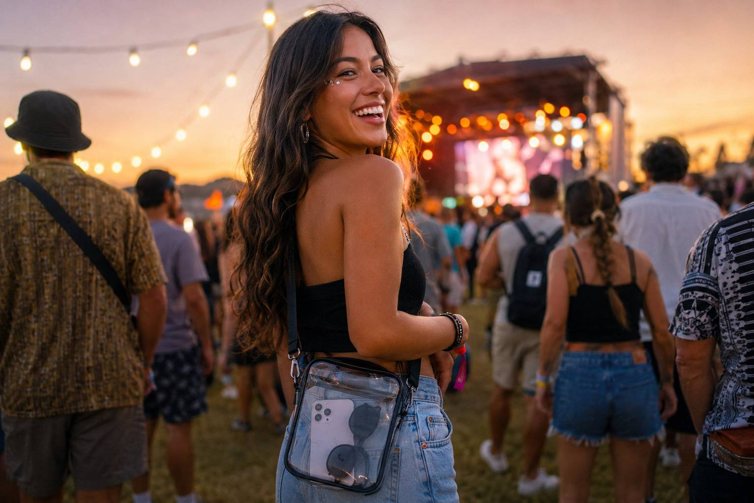 Woman carrying a clear crossbody bag at an outdoor concert
