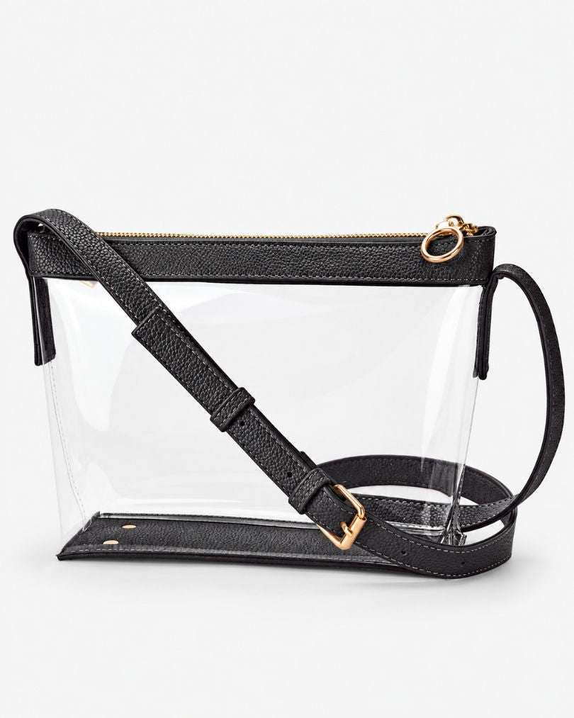 Black clear crossbody purse with vegan leather trim, gold-tone zipper and buckle, empty, in a three-quarter view on white