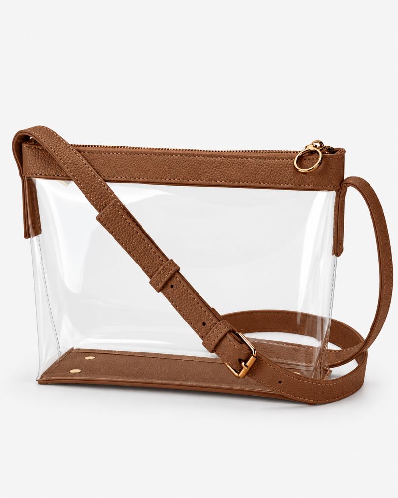 Brown clear crossbody purse with vegan leather trim, gold-tone zipper and buckle, empty, in a three-quarter view on white
