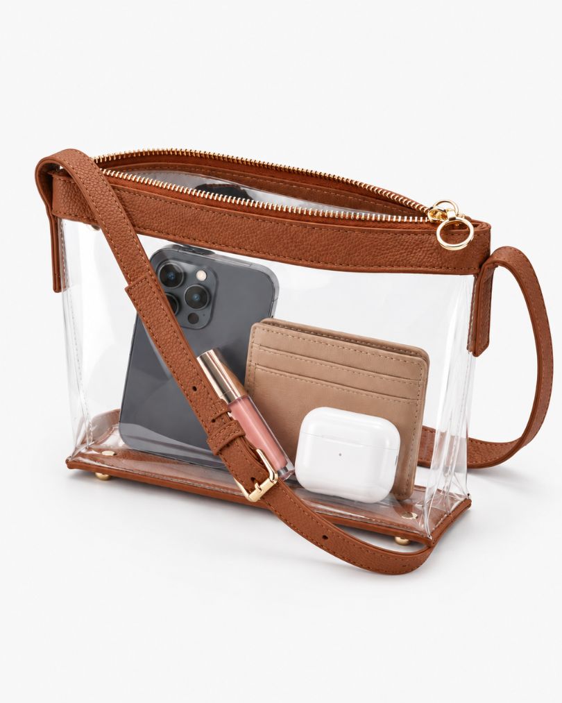 Brown clear purse with the zipper open, packed with a smartphone, a card wallet, a lip gloss and an earbuds case, on white