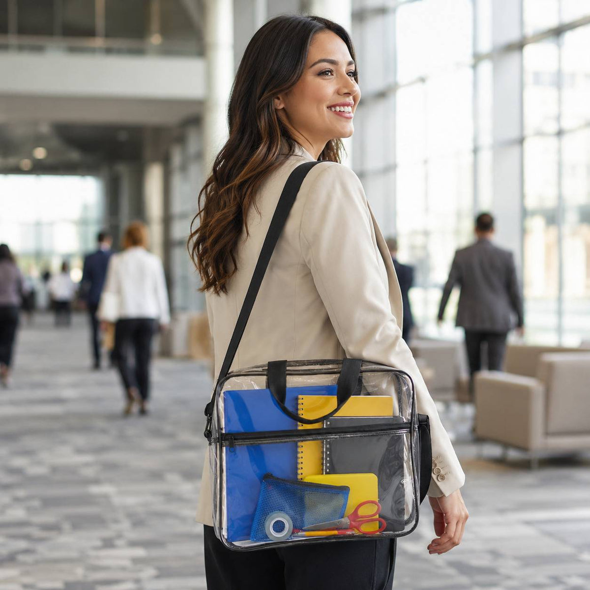 Woman walking through an office hallway with the clear portfolio briefcase over her shoulder, back view.