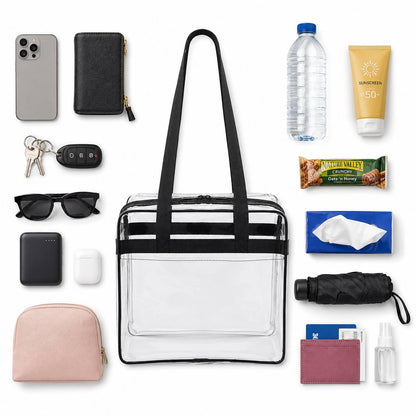 Top-down flatlay of the clear stadium tote bag surrounded by a phone, wallet, keys, sunglasses, sunscreen, and snacks.