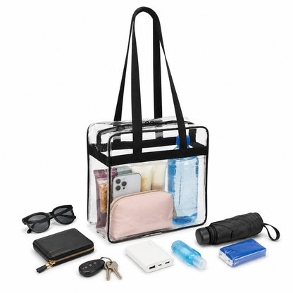 Clear stadium tote bag packed with a water bottle, phone, cosmetic pouch, and toiletries, surrounded by travel essentials.