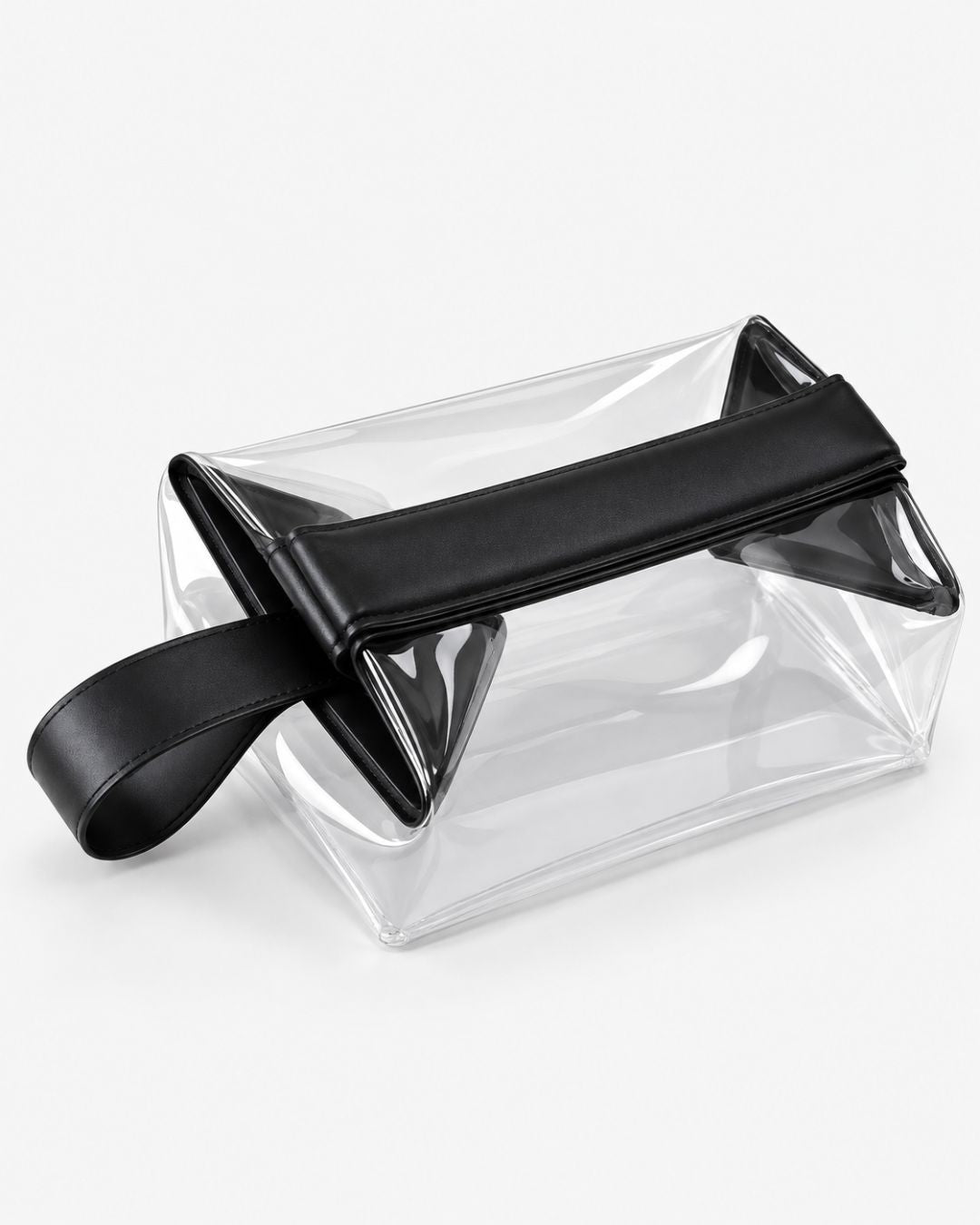 Small clear toiletry bag with black trim, padded fold-over magnetic closure and carry handle, shown empty on a white background.