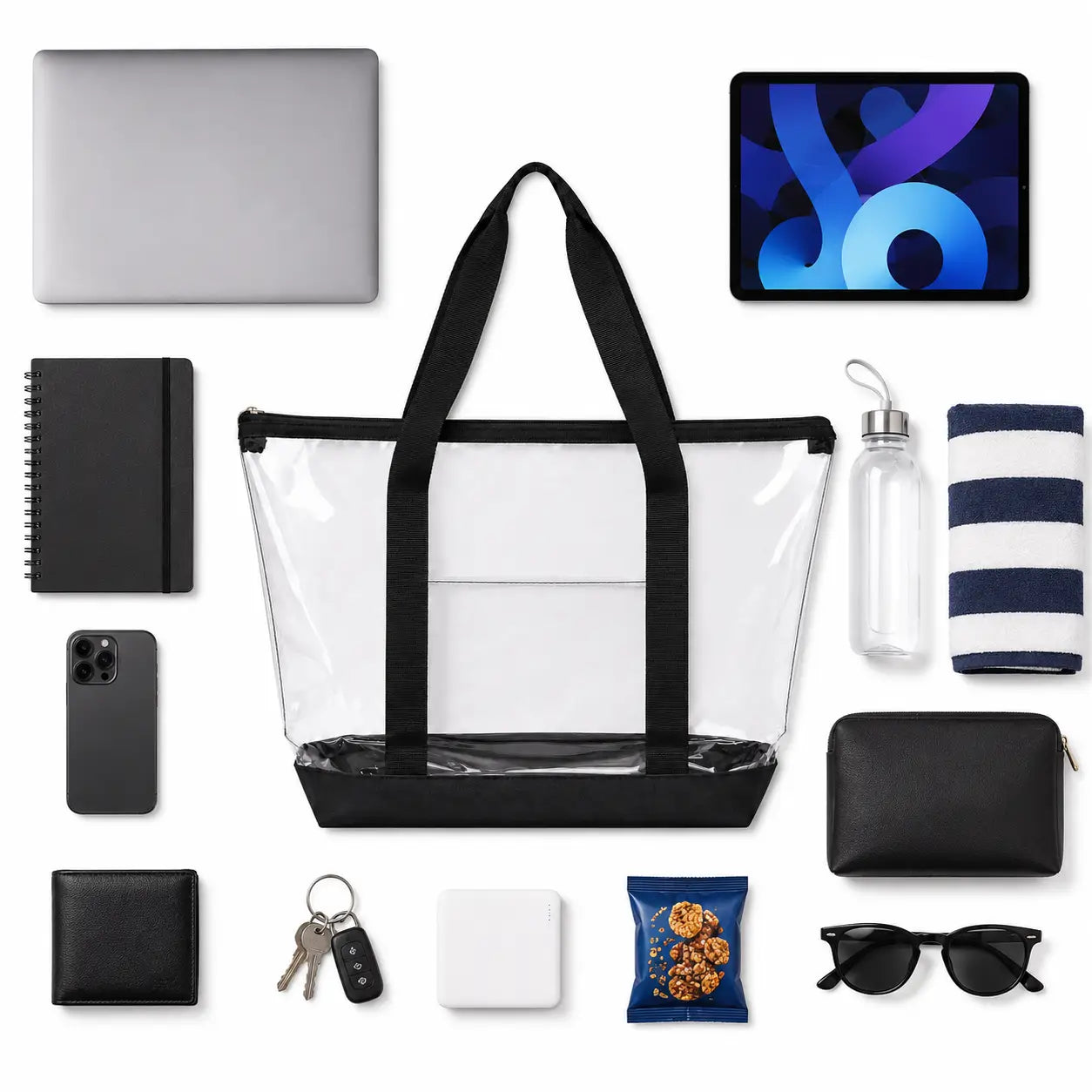 Large clear tote bag laid flat beside a tablet, phone, wallet and sunglasses