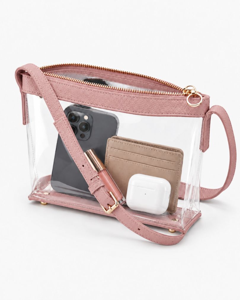Pink clear purse with the zipper open, packed with a smartphone, a card wallet, a lip gloss and an earbuds case, on white