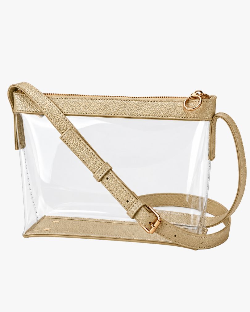 Rose gold clear crossbody purse with vegan leather trim, gold-tone zipper and buckle, empty, in a three-quarter view on white